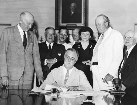 Roosevelt signs the Social Security Act, August 14, 1935